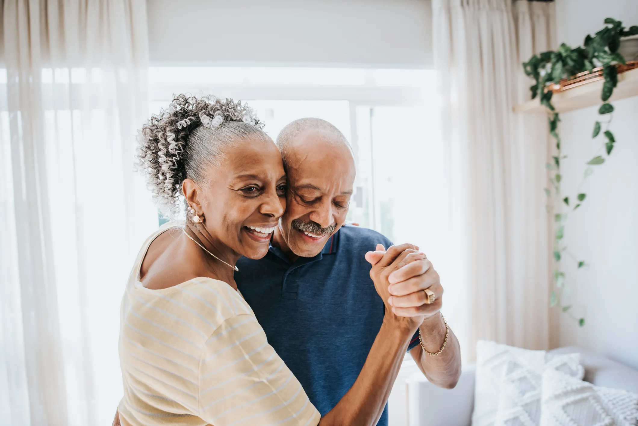 Older couple dancing together in their living room