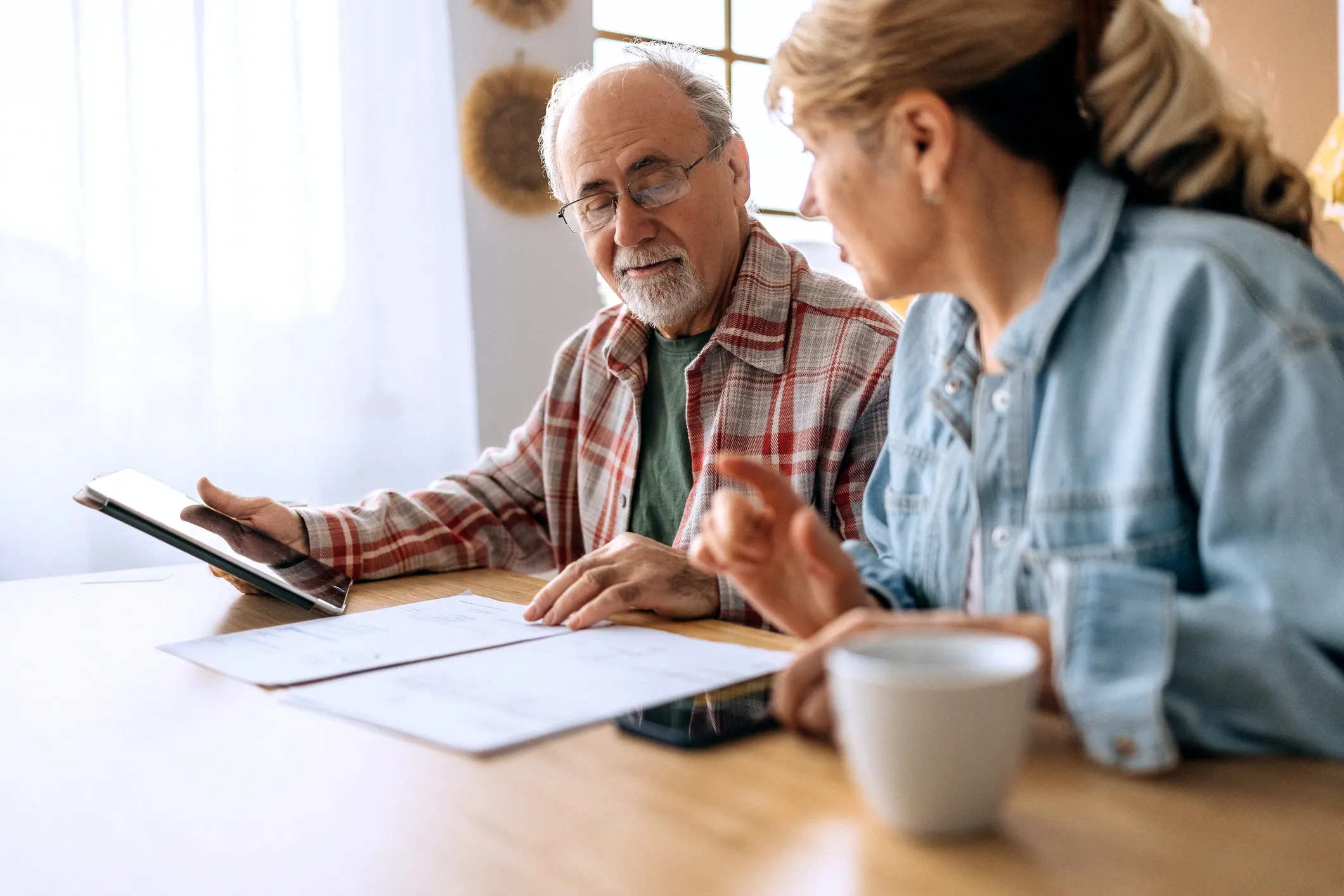 Elderly couple discussing documents at table.